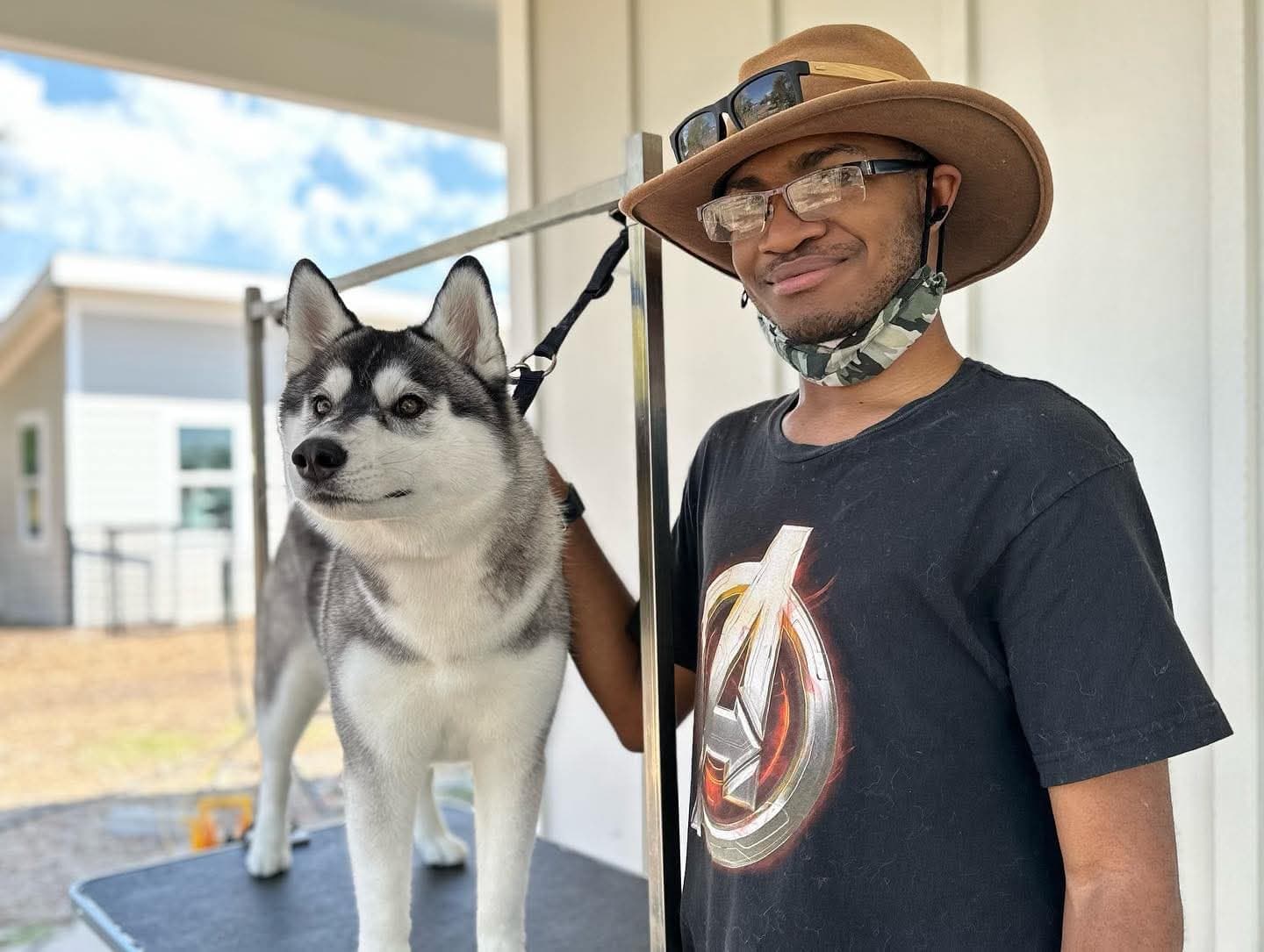 Volunteer helping groom a Central Texas Husky dog on a grooming table