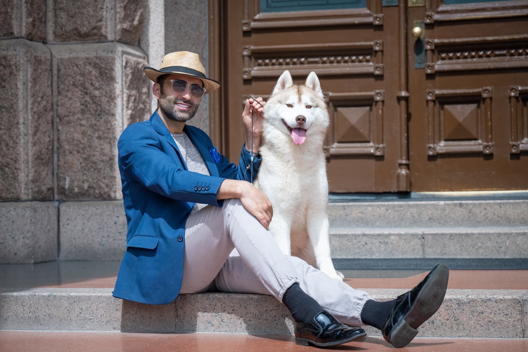 Esteban sitting beside his handler on stone steps