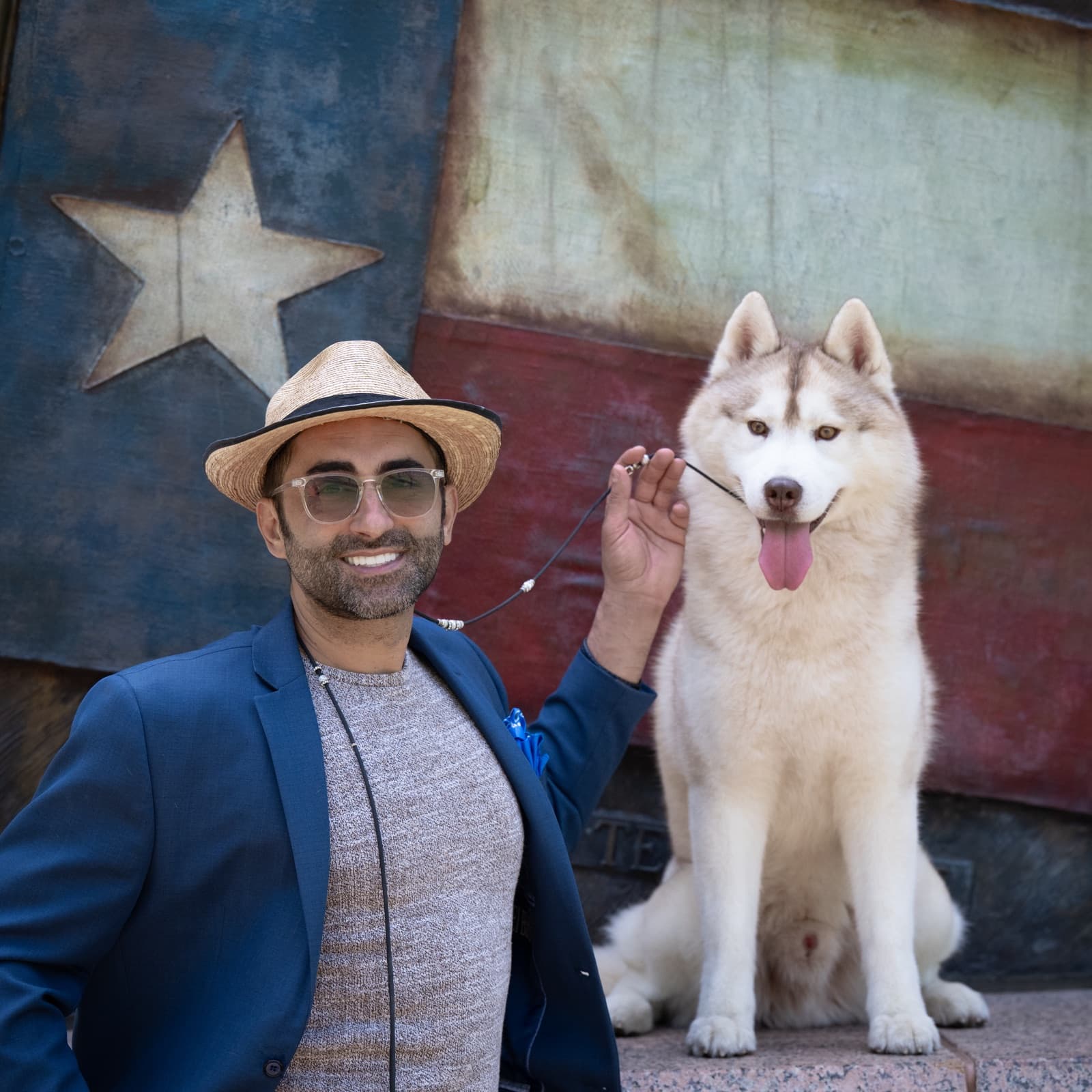 Esteban and his handler posed in front of a Texas flag backdrop