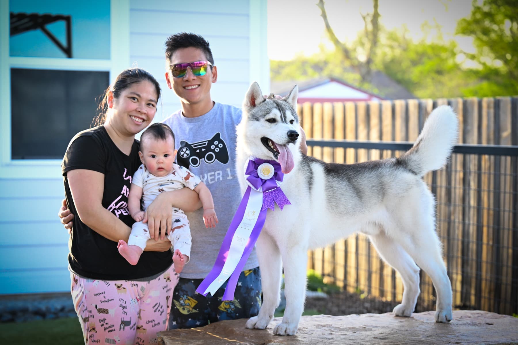Rodeo wearing a purple ribbon while standing beside his family outdoors