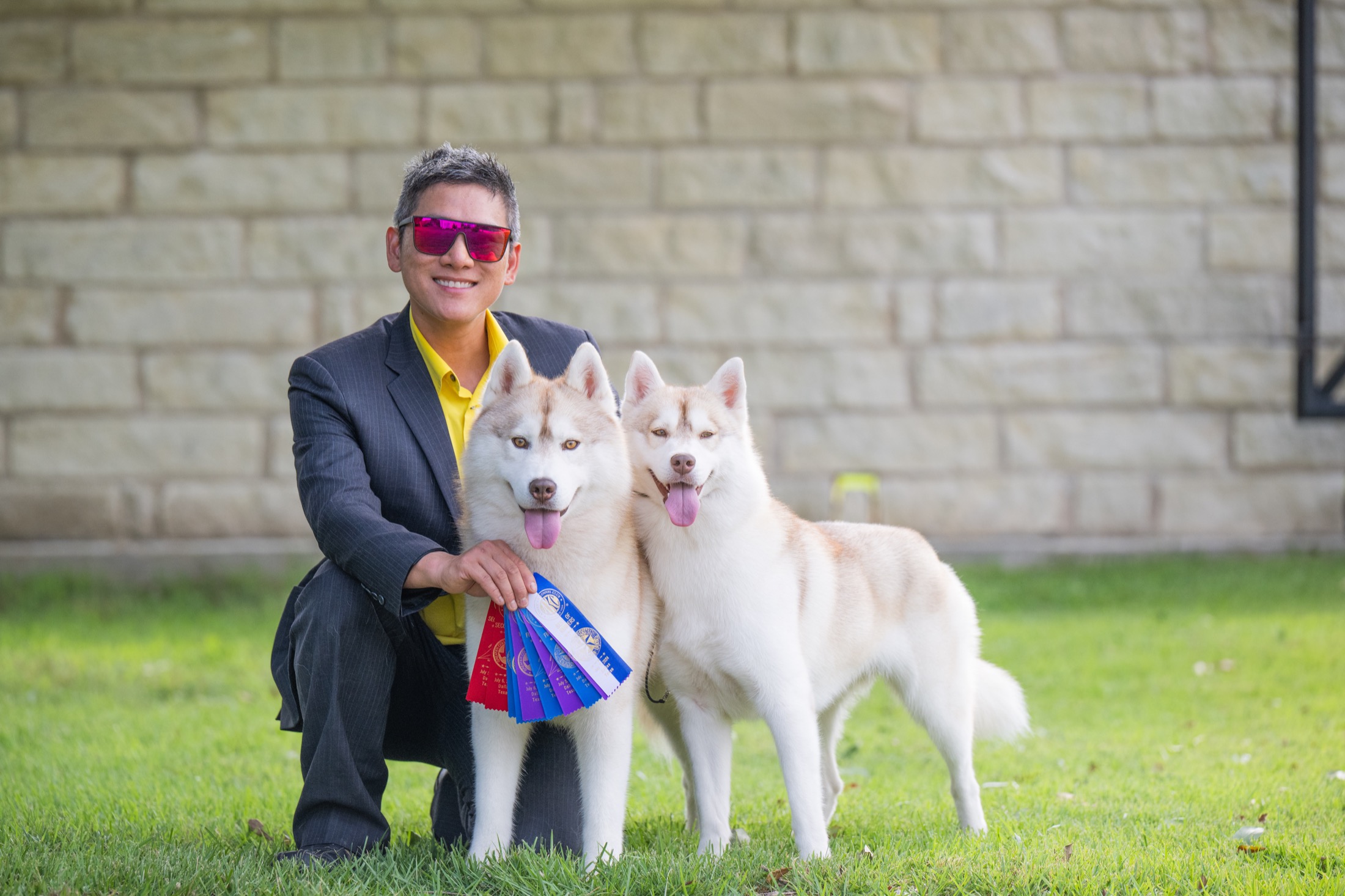 Ben with two light red and white Arkinlight Siberian Huskies and show ribbons