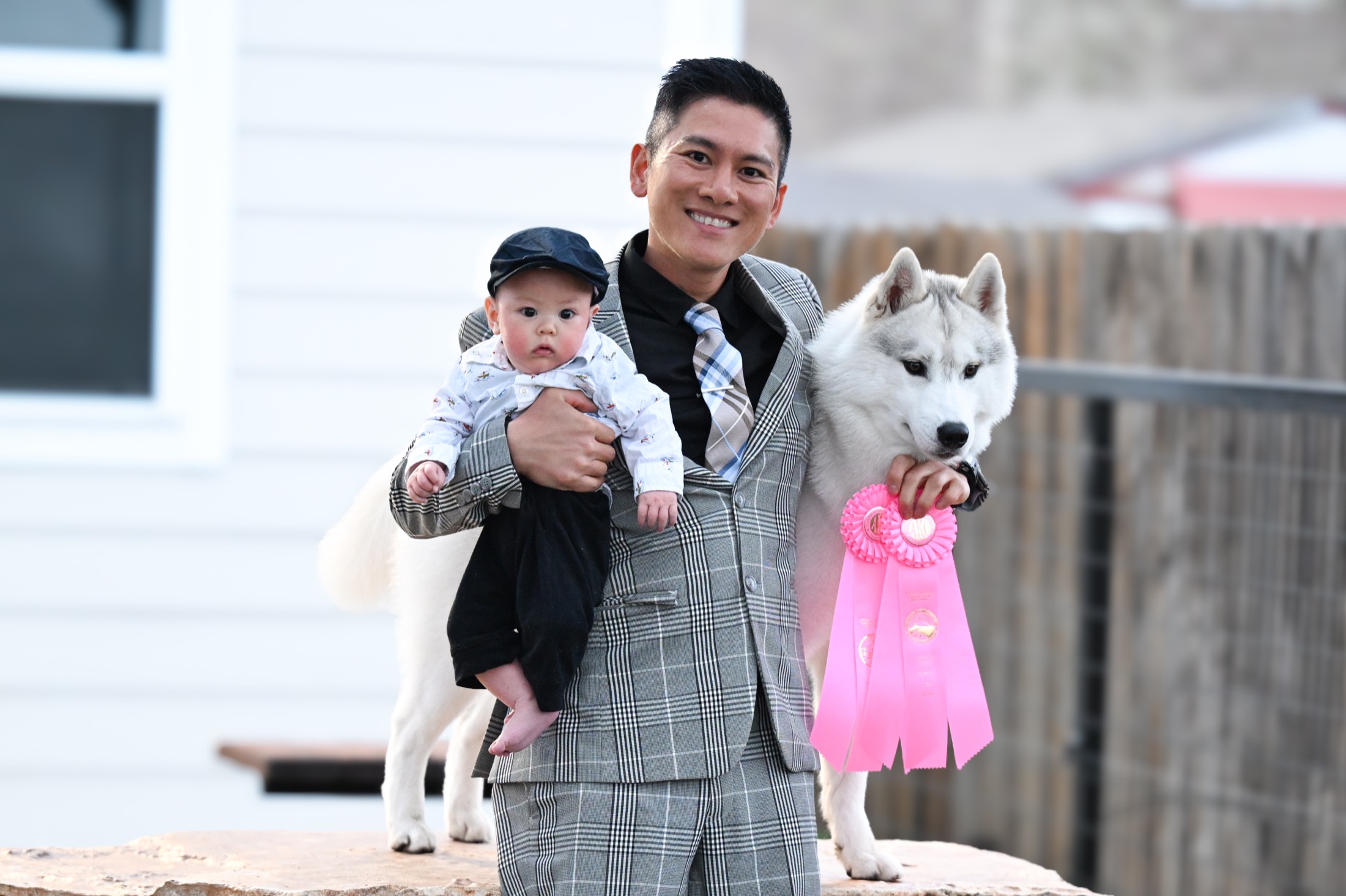 Ben holding Max beside an Arkinlight Siberian Husky with a show ribbon